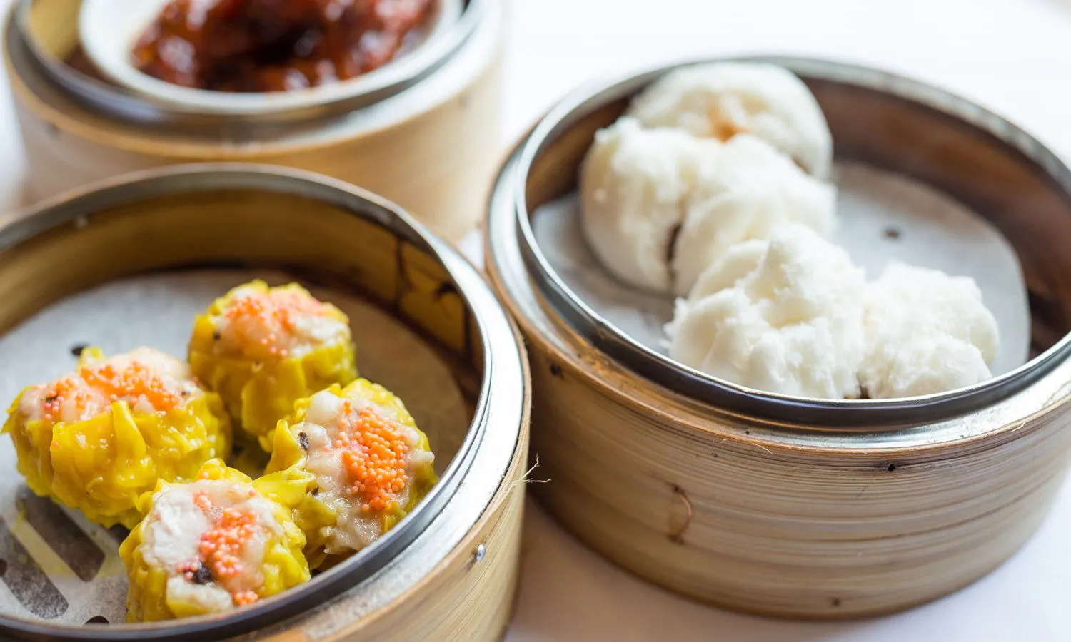 Siu mai with fish roe and fluffy char siu bao in bamboo baskets