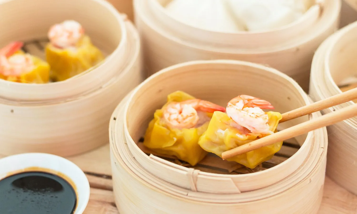 Shrimp siu mai picked by chopsticks in bamboo steamer